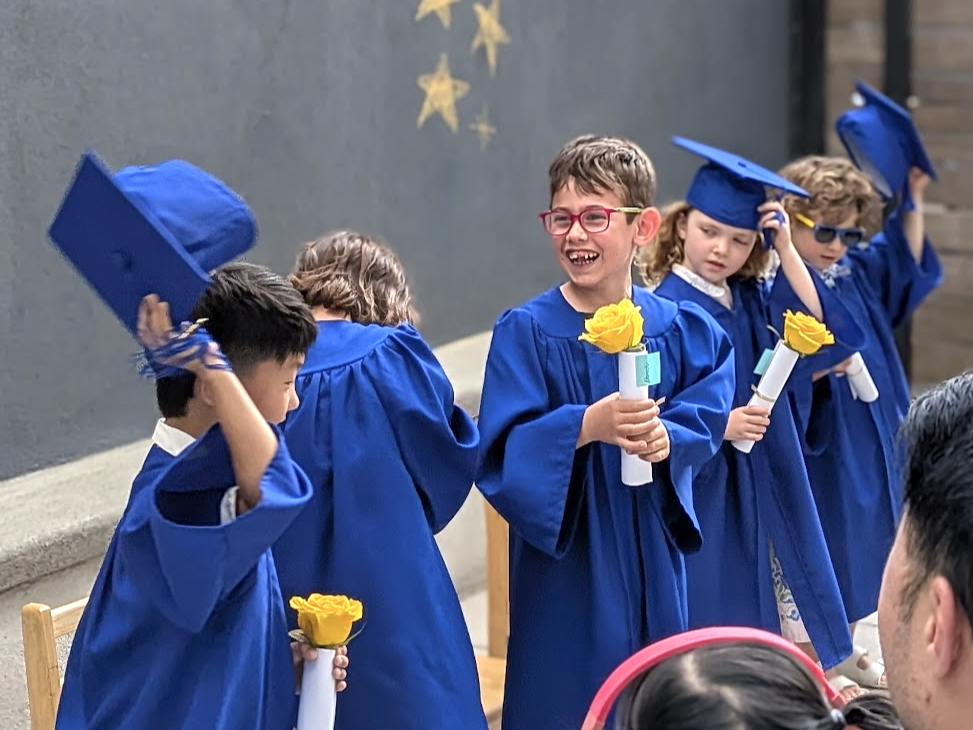 Carrig Montessori children celebrating graduation in blue caps and gowns
